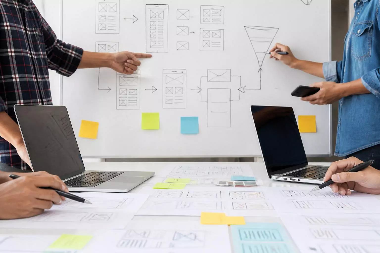 Equipo de UX dibuja el recorrido del usuario y el embudo de conversión en una pizarra